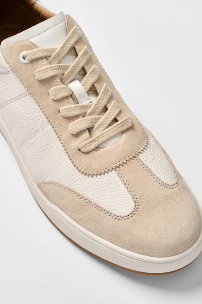 Beige sneaker with white laces on a light gray background