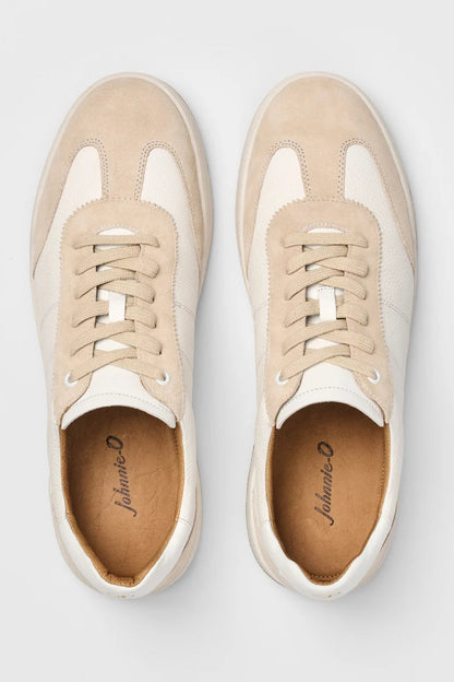 Pair of beige and white sneakers on a light gray background