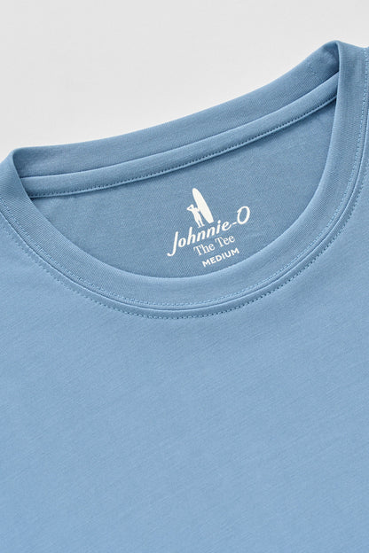 Close-up of a blue t-shirt with a brand logo on the collar against a light gray background