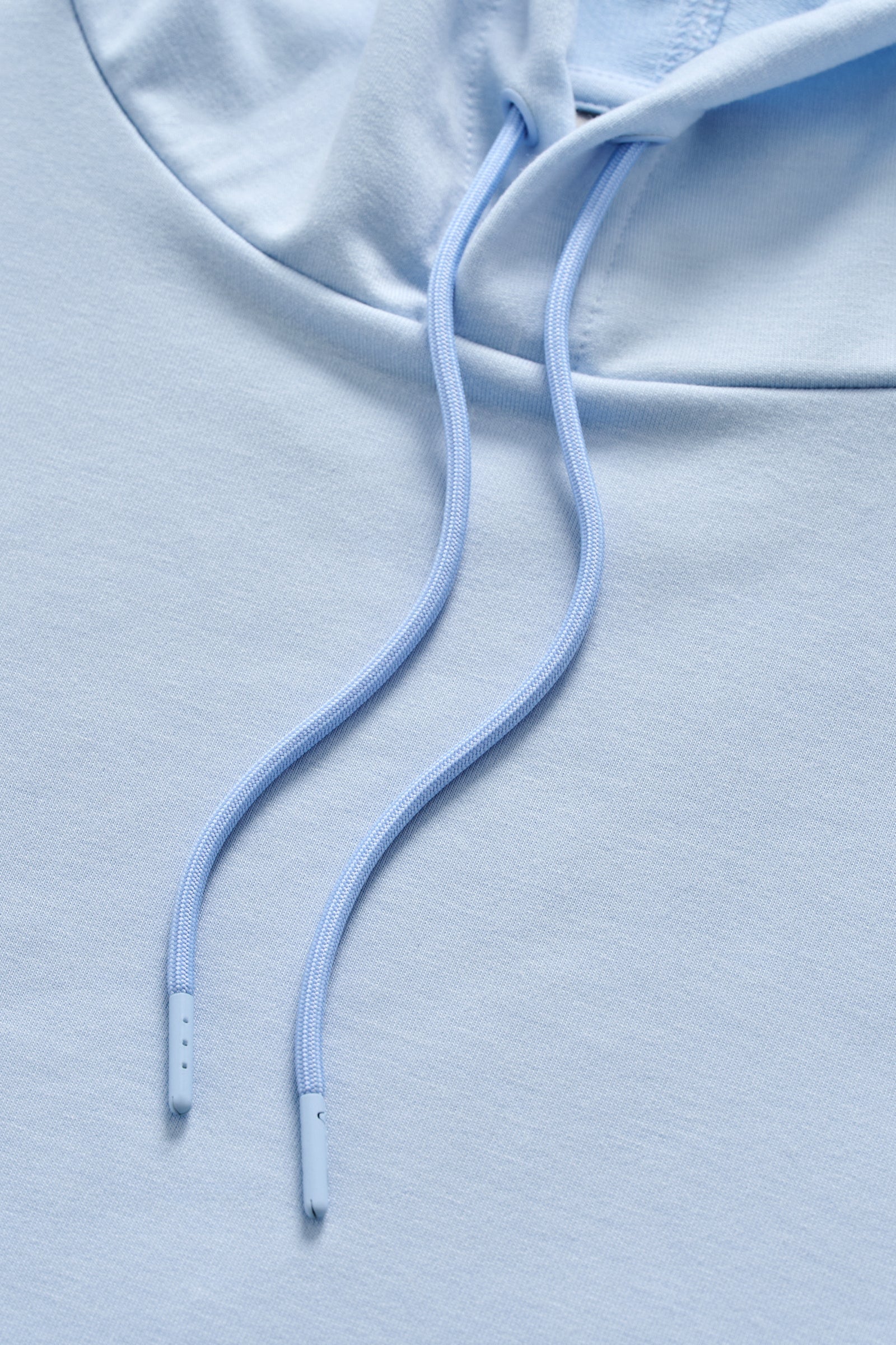 Close-up of a light blue hoodie with a focus on the drawstring.