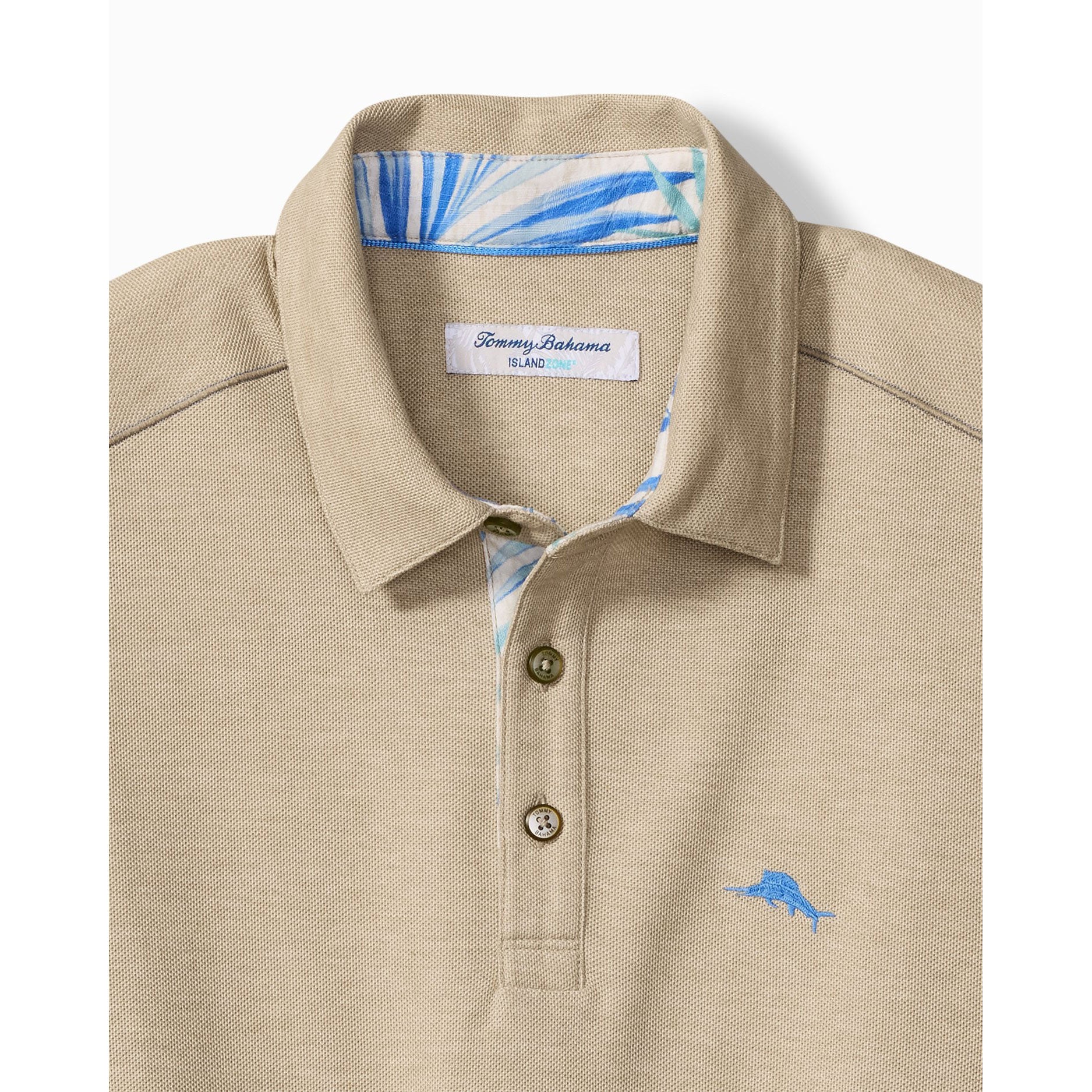 Beige polo shirt with floral collar and Tommy Bahama logo on a white background