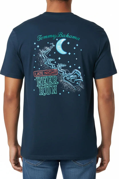 A man wearing a navy blue t-shirt from the back, featuring a graphic design with the text 'Tommy Bahama' and 'Late Night Beer Run' in teal and red, alongside a crescent moon and stars.