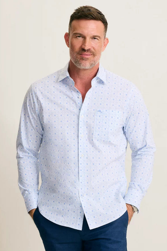 Man wearing a light blue patterned shirt against a beige background