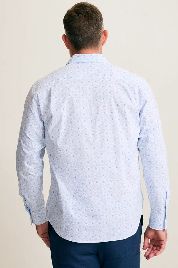 Man wearing a light blue patterned shirt against a plain background