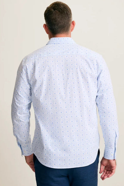 Man wearing a light blue patterned shirt against a plain background