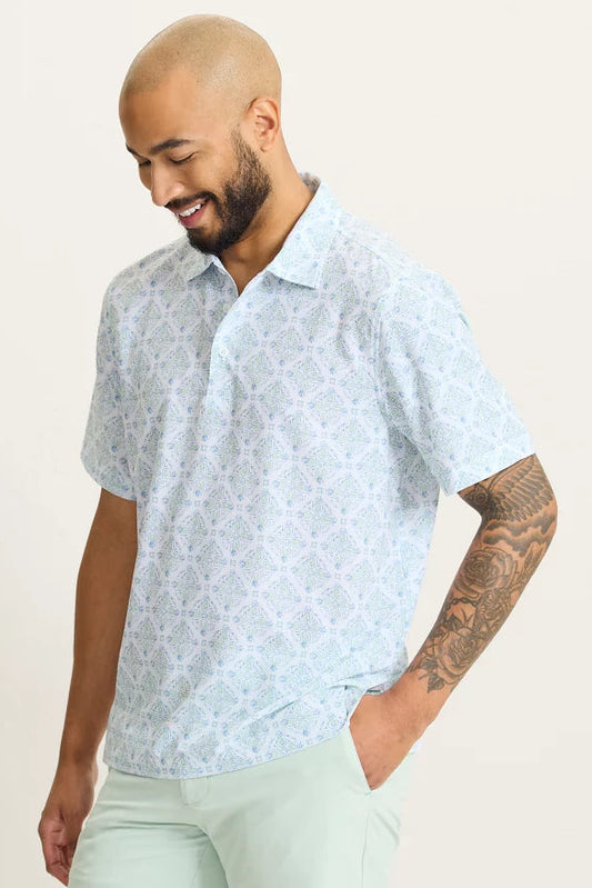 Man wearing a light blue patterned shirt against a plain background