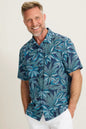 Man wearing a blue leaf-patterned shirt against a white background