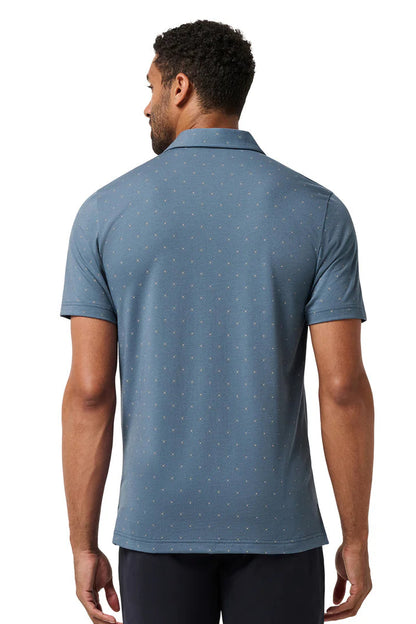 Man wearing a blue polo shirt with a subtle pattern on a white background