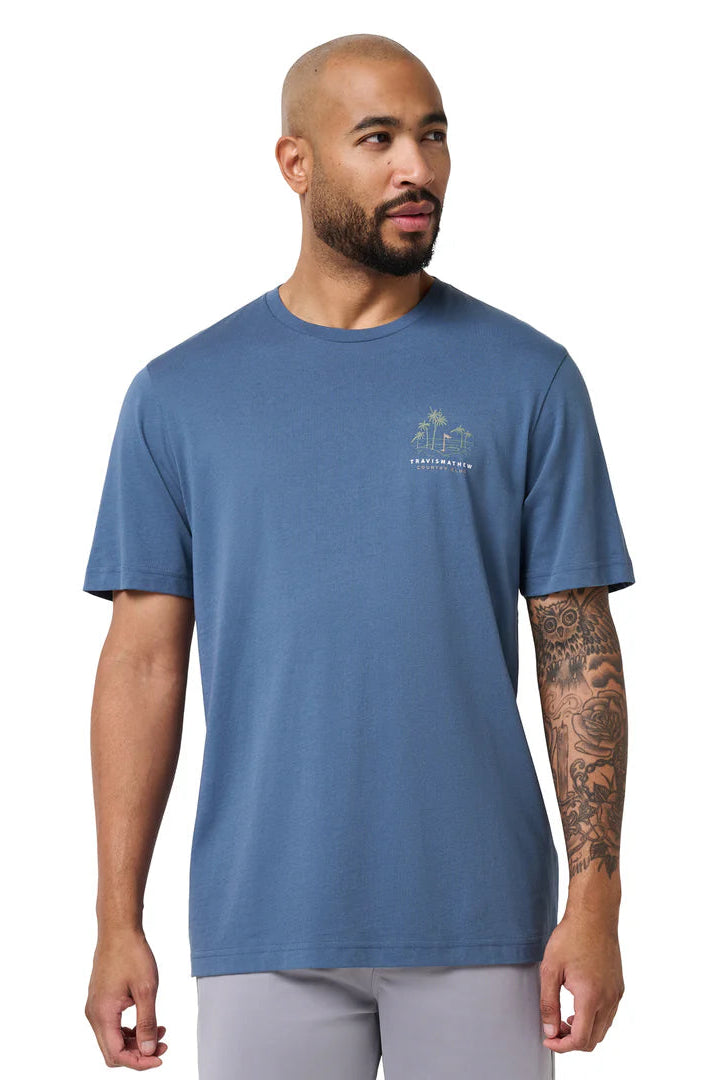 Man wearing a blue t-shirt with a logo on a white background
