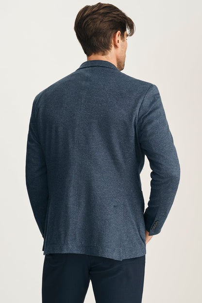 Man wearing a blue blazer from behind on a light background