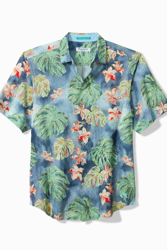 Tropical patterned shirt with leaves and flowers on a white background