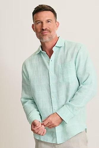 Man wearing a light blue shirt against a plain background