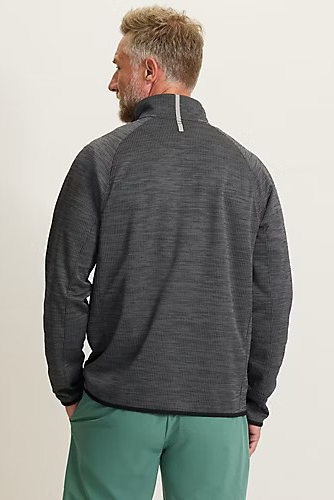 Man wearing a gray fleece pullover and green pants on a plain background