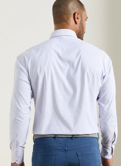 Man wearing a light blue checkered shirt and blue pants against a plain background