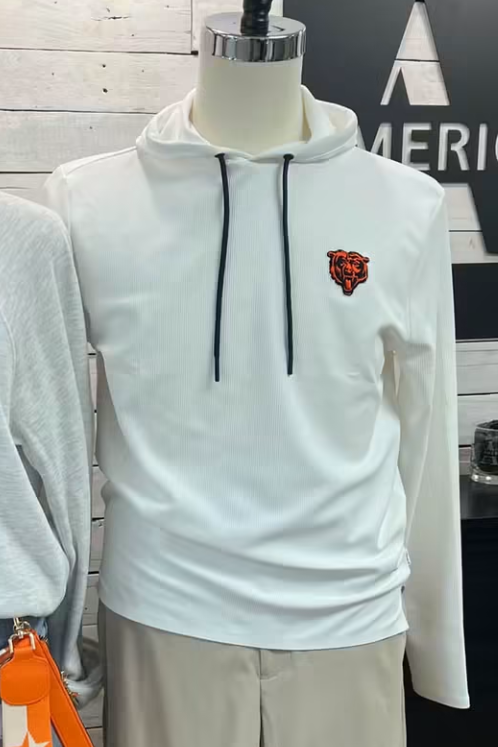 A boutique display showing two mannequins wearing coordinated outfits. The left mannequin wears a light gray sweatshirt with a large orange and blue 'BEAR DOWN' graphic, paired with denim shorts and an orange bag.