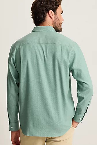 A man wearing a sage green long-sleeve button-down shirt, shown from the back against a light beige studio background.